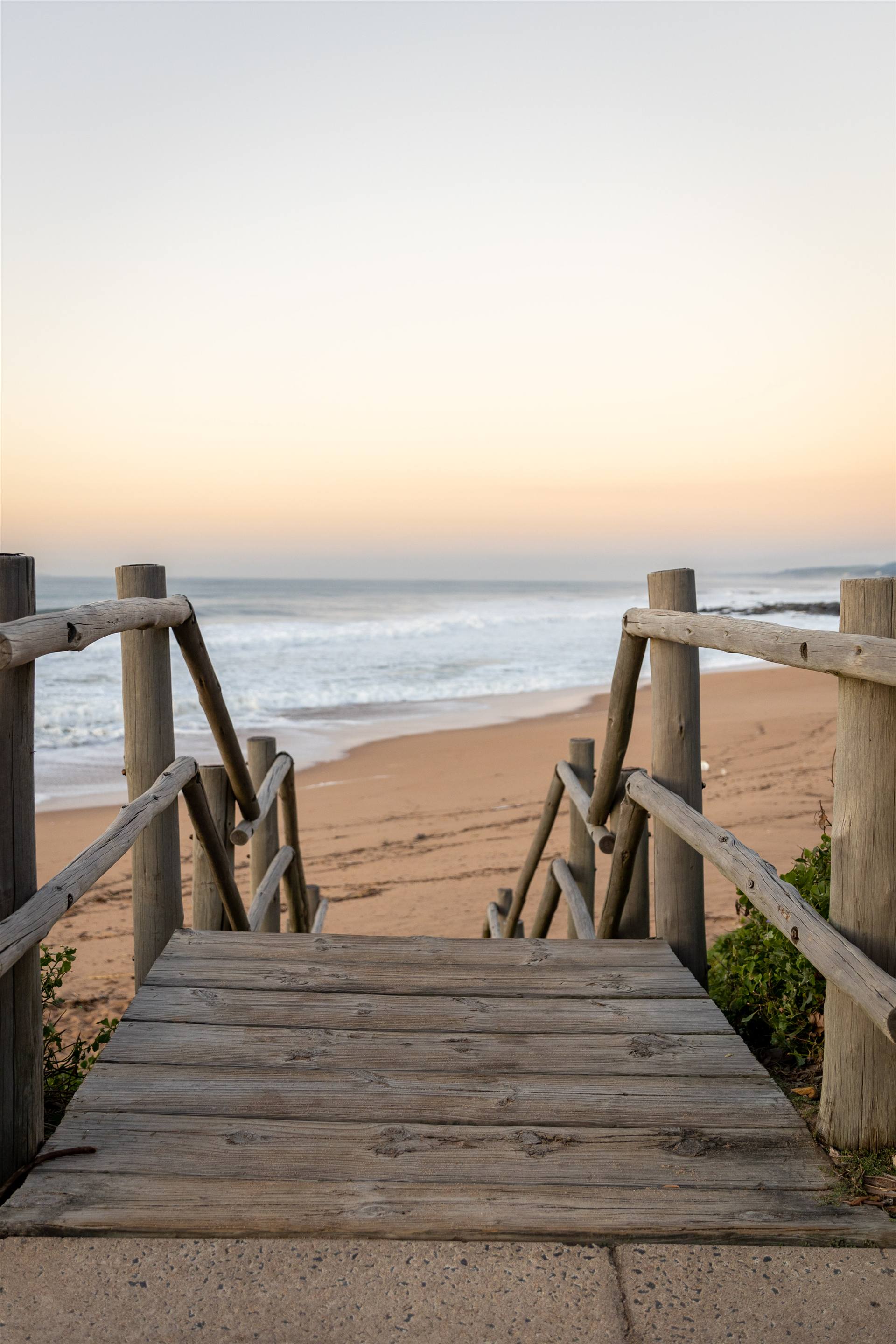 Timber steps leading down to the beach at sunrise on the Dolphin Coast